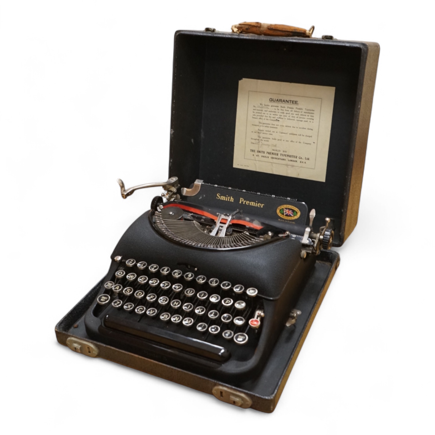 A cased portable Smith Premier Model 5 typewriter, with original guarantee sales label to the inside of the lid dated 22 January 1946.